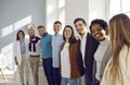 Multiethnic team of happy supportive business people standing in office, hugging and smiling Royalty Free Stock Photo