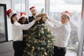 Multiethnic team of people putting christmas tree decor in festive office Royalty Free Stock Photo