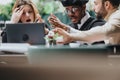 Multiethnic teamwork in discussion at a restaurant with a shocked woman looking at laptop. Royalty Free Stock Photo