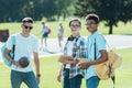 multiethnic teenage boys with books and backpacks smiling at camera