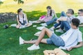 multiethnic teenage students sitting on grass talking and studying Royalty Free Stock Photo