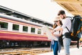 Multiethnic traveler couple using generic local map navigation together at train station platform. Asia tourism trip concept Royalty Free Stock Photo