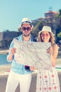 Multiethnic traveler couple using generic local map together on sunny day.