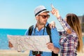 Multiethnic traveler couple using generic local map together on sunny day.