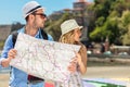 Multiethnic traveler couple using generic local map together on sunny day. Royalty Free Stock Photo