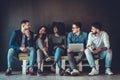 Multiethnic university students studying together. Young people working with tests and gadgets, sitting on the couch Royalty Free Stock Photo