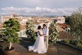 Multiethnic wedding couple. Destination fine-art wedding in Florence, Italy. A wedding ceremony on the roof of the