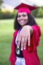 Multiethnic woman in her graduation cap and gown showing her class ring