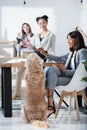 Multiethnic women in formal wear working at office with dog Royalty Free Stock Photo