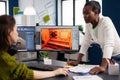 Multiethnic women game designer looking at computer