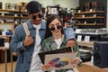 Multiethnic young couple holding vinyl records in music store and smiling Royalty Free Stock Photo