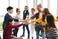 Multiethnic young team stack hands together as trusted unity and teamwork in modern office.