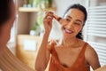 Multiethnic young woman applying make up in the morning Royalty Free Stock Photo