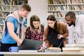 Multiethnical attractive smiling team of students, coworkers which are working and communicating together over home task Royalty Free Stock Photo