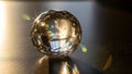 Multifaceted crystal sphere sits on a flat surface illuminated by Royalty Free Stock Photo