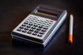 Multifunctional engineering calculator with a pencil on a dark desk. Macro. Soft focus. Royalty Free Stock Photo