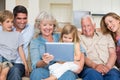 Multigeneration family using digital tablet Royalty Free Stock Photo