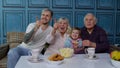 Multigenerational family watch TV with young girl kid at home, laughing while watching cartoon movie Royalty Free Stock Photo