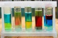 Multilayer systems of colored liquid insoluble substances in test tubes. Royalty Free Stock Photo