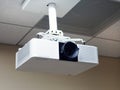 Multimedia projector hanging on the ceiling of conference room. Royalty Free Stock Photo