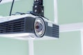 Multimedia projector hanging on the ceiling of modern conference room. Monochrome indoors picture. Royalty Free Stock Photo