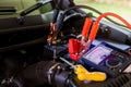 Multimeter for check voltage in battery with blurry yellow screw driver for repair service. Auto mechanic working in garage.