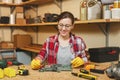 Beautiful caucasian young brown-hair woman working in carpentry workshop at table place. Royalty Free Stock Photo