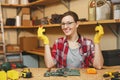 Beautiful caucasian young brown-hair woman working in carpentry workshop at table place. Royalty Free Stock Photo