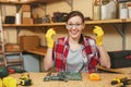 Beautiful caucasian young woman working in carpentry workshop at table place Royalty Free Stock Photo