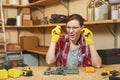 Beautiful caucasian young woman working in carpentry workshop at table place Royalty Free Stock Photo