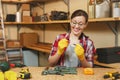 Beautiful caucasian young woman working in carpentry workshop at table place Royalty Free Stock Photo