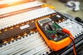 The multimeter is lying on the battery of an electric car on a blurry background