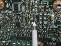 Multimeter probes examining a circuit board