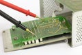 Multimeter probes on printed circuit board.