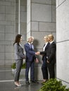 Multinational business people meeting shaking hands in lobby of modern office building Royalty Free Stock Photo