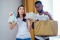 Multinational couple choosing textile or polyester bag.african american man and asian woman save planet standing at Royalty Free Stock Photo