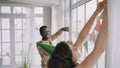 Multinational couple hangs colorful pennant banners in room