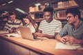 Multinational group of cheerful students studying in the university library. Royalty Free Stock Photo