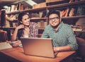 Multinational group of cheerful students studying in the university library. Royalty Free Stock Photo