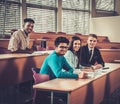 Multinational group of cheerful students taking an active part in a lesson while sitting in a lecture Hall. Royalty Free Stock Photo