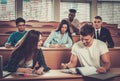 Multinational group of cheerful students taking an active part in a lesson while sitting in a lecture Hall. Royalty Free Stock Photo