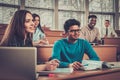 Multinational group of cheerful students taking an active part in a lesson while sitting in a lecture Hall. Royalty Free Stock Photo