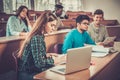 Multinational group of cheerful students taking an active part in a lesson while sitting in a lecture Hall. Royalty Free Stock Photo