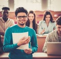 Multinational group of cheerful students taking an active part in a lesson while sitting in a lecture hall. Royalty Free Stock Photo