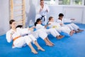 Teenagers performing core twist with punches during martial arts training