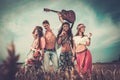 Multinational hippie friends with guitar in a wheat field