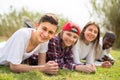 Multinational modern teens lie in the park on the grass Royalty Free Stock Photo