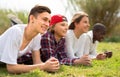 Multinational modern teens lie in the park on the grass Royalty Free Stock Photo