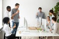 Multinational work group talking and eating pizza at workplace Royalty Free Stock Photo