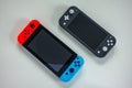 A multiplayer Nintendo Switch and single player Nintendo Switch Lite gaming consoles side by side Royalty Free Stock Photo